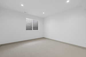 Empty room with carpet flooring and recessed lighting