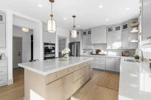 Kitchen featuring open shelves, light brown cabinets, light stone counters, light wood-style flooring, and recessed lighting