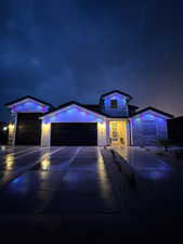 View of front of house featuring stone siding, an attached garage, and driveway