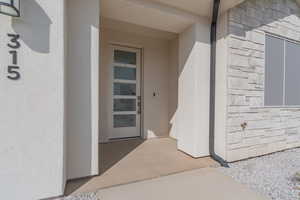 Doorway to property with stone siding and stucco siding