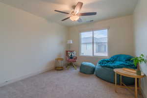 Sitting room featuring carpet and ceiling fan
