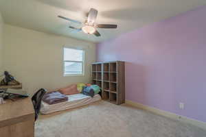 Carpeted bedroom featuring baseboards and ceiling fan