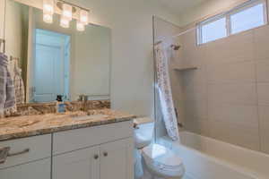 Full bathroom with shower / tub combo with curtain and vanity