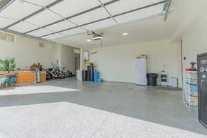 Garage featuring freestanding refrigerator and a garage door opener