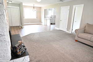 Living room with light colored carpet, a chandelier, and light wood-style flooring