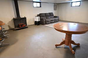 Living room with a wood stove, healthy amount of natural light, concrete floors, and electric panel