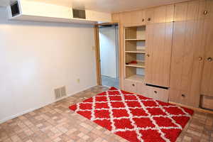 Unfurnished bedroom with brick patterned floors and baseboards