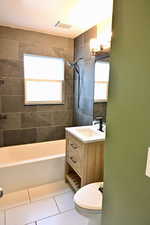 Full bath with shower / washtub combination, vanity, and light tile patterned floors