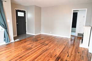 Entryway featuring dark wood-type flooring and baseboards