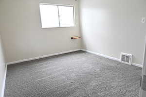 Empty room featuring carpet floors and baseboards