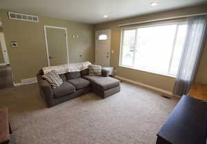 Carpeted living area featuring baseboards and recessed lighting