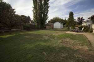 View of yard featuring a shed and a patio area