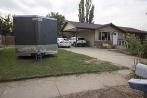 View of side of home with an attached carport, driveway, and extra parking
