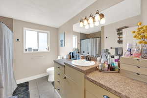 Bathroom with vanity, light tile patterned floors, and a shower with curtain