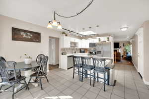 Dining room featuring light tile patterned flooring and track lighting