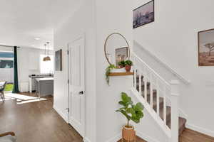 Staircase with wood finished floors and recessed lighting