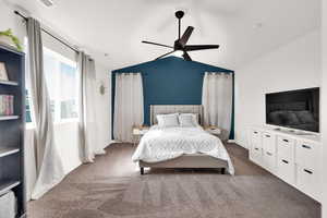 Bedroom with light carpet, vaulted ceiling, and a ceiling fan