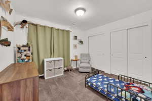Bedroom featuring dark colored carpet, a textured ceiling, and a closet