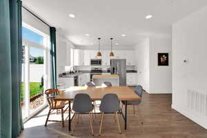Dining area with recessed lighting and dark wood-type flooring