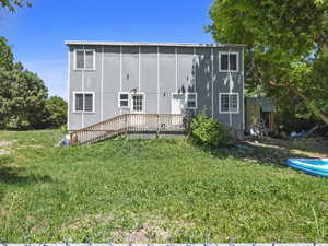 Back of property with a deck and a yard