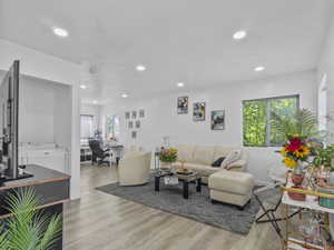 Living area featuring a desk, light wood-style floors, and recessed lighting