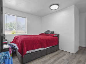Bedroom featuring a textured ceiling and wood finished floors