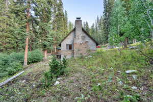 View of property exterior featuring a chimney and brick siding