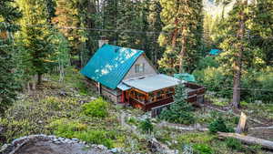 View of cabin featuring a forest view
