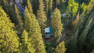 Aerial view of property and surrounding area featuring a forest