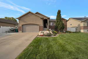 Single story home with brick siding, a gate, concrete driveway, solar panels, and stucco siding