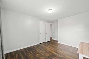 Unfurnished bedroom featuring dark wood finished floors and a closet