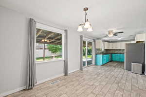 Kitchen with hanging light fixtures, stainless steel appliances, a chandelier, and plenty of natural light
