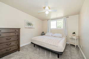 Bedroom with carpet flooring, ceiling fan, and lofted ceiling