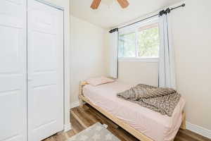 Bedroom featuring wood finished floors, a ceiling fan, and a closet