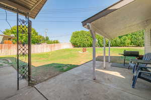 Fenced backyard with a patio area and a grill