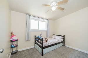 Carpeted bedroom with baseboards and ceiling fan