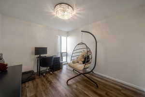Office area with dark wood-style floors and a chandelier