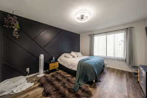 Bedroom with wood finished floors and baseboards