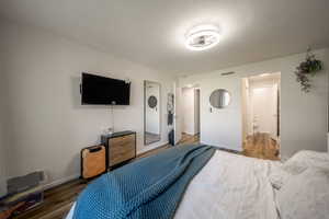Bedroom with wood finished floors and ensuite bathroom