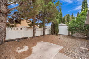 Fenced backyard featuring a storage shed