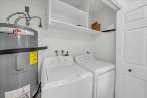 Washroom featuring water heater and independent washer and dryer