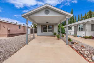 Entrance to property with a carport and a porch