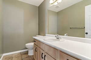 Bathroom with vanity, light tile patterned floors, and a textured ceiling