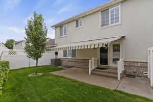 Back of property featuring stucco siding, brick siding, a fenced backyard, and a patio area