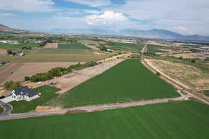 Aerial overview of property's location with a mountain backdrop, large plots for crops, and rural landscape