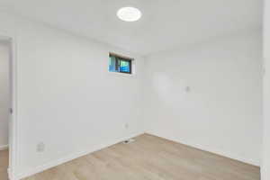 Unfurnished room with light wood-style flooring and baseboards