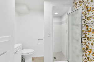 Bathroom featuring a shower stall, light tile patterned floors, and vanity