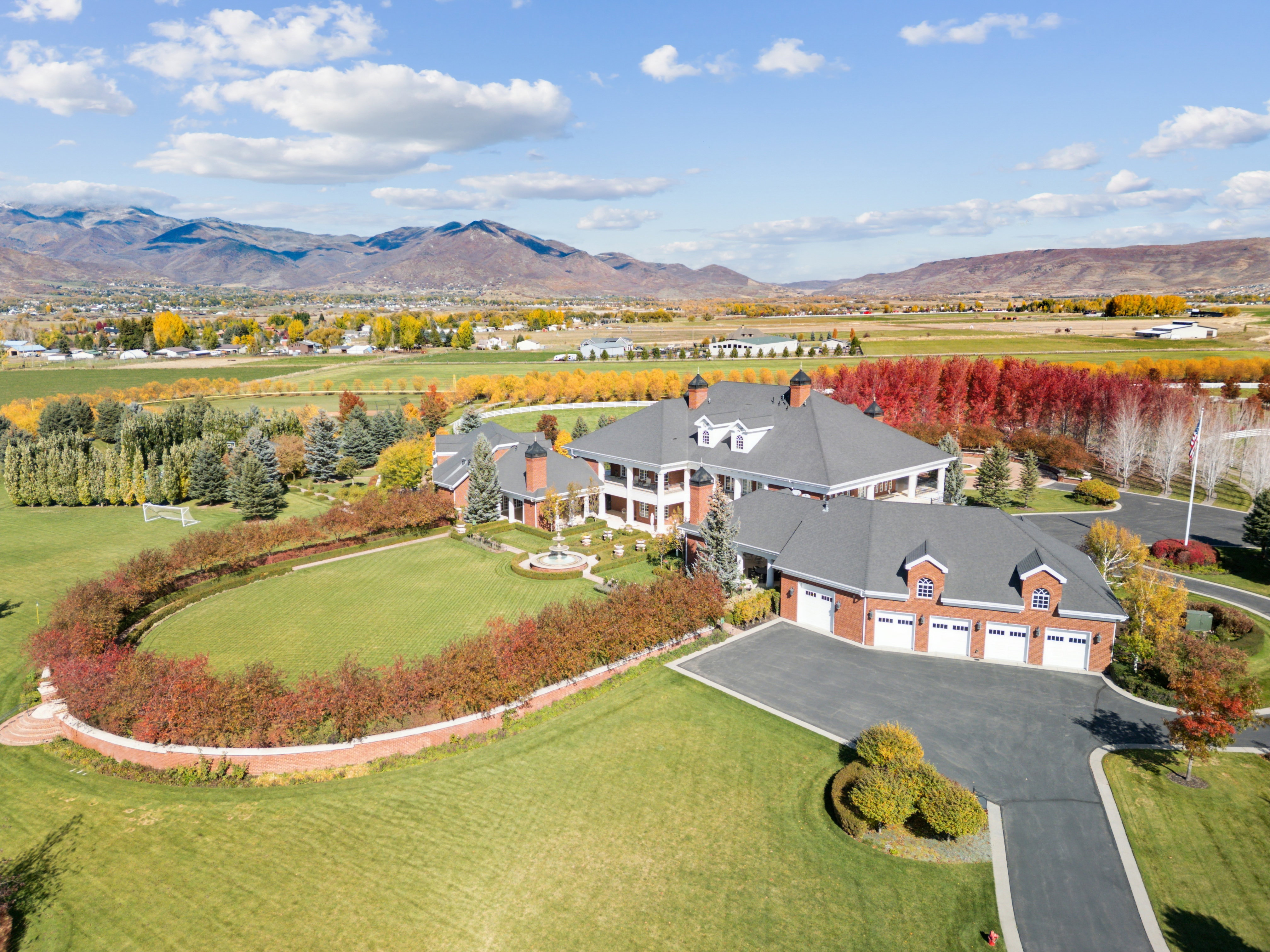 Expansive estate featuring a brick exterior, multiple dormer windows, and a multi-car garage