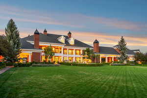 Back of property with a yard, a balcony, and a chimney