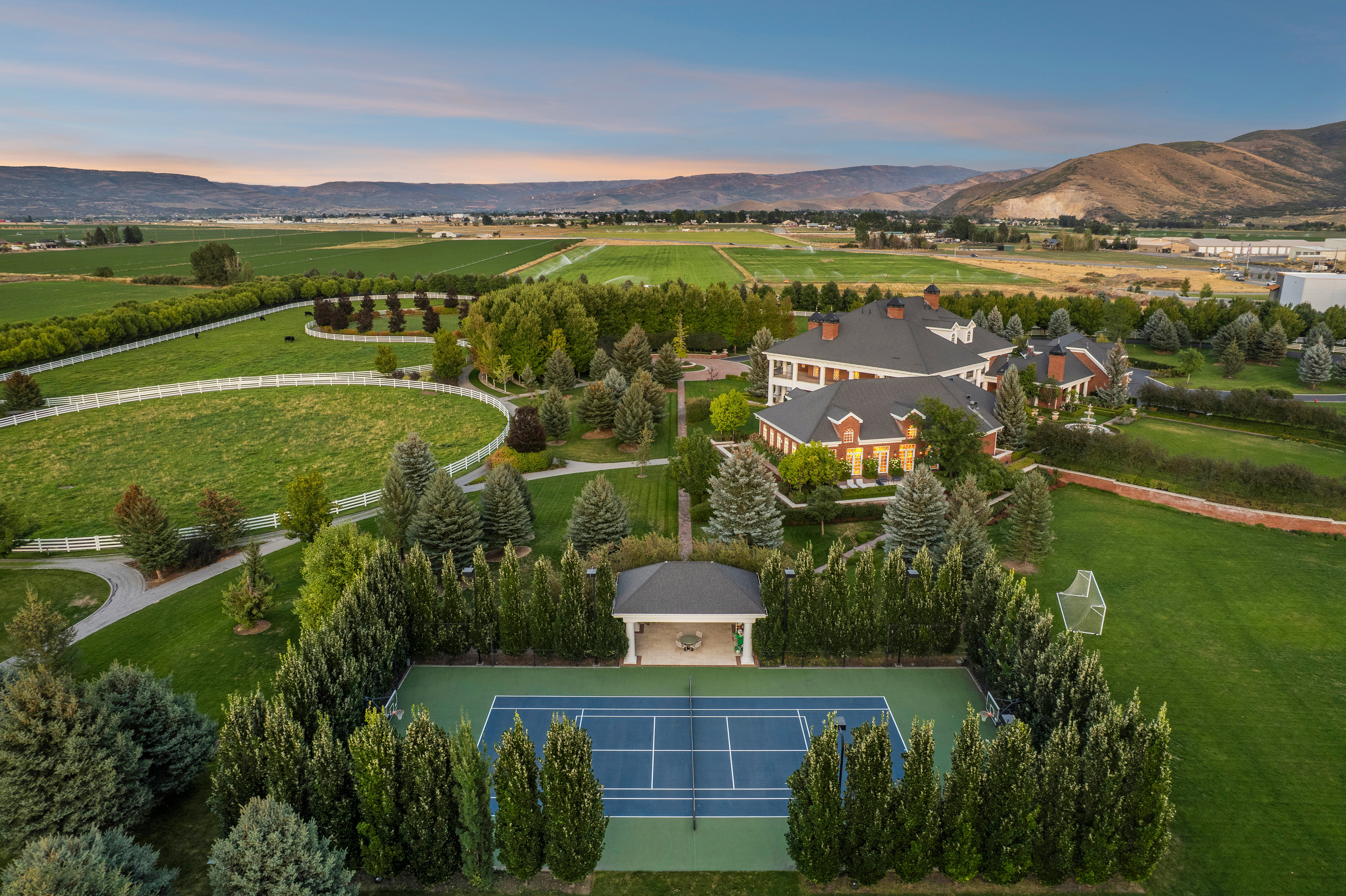 Expansive property featuring a private tennis court, covered pavilion, and meticulously landscaped grounds